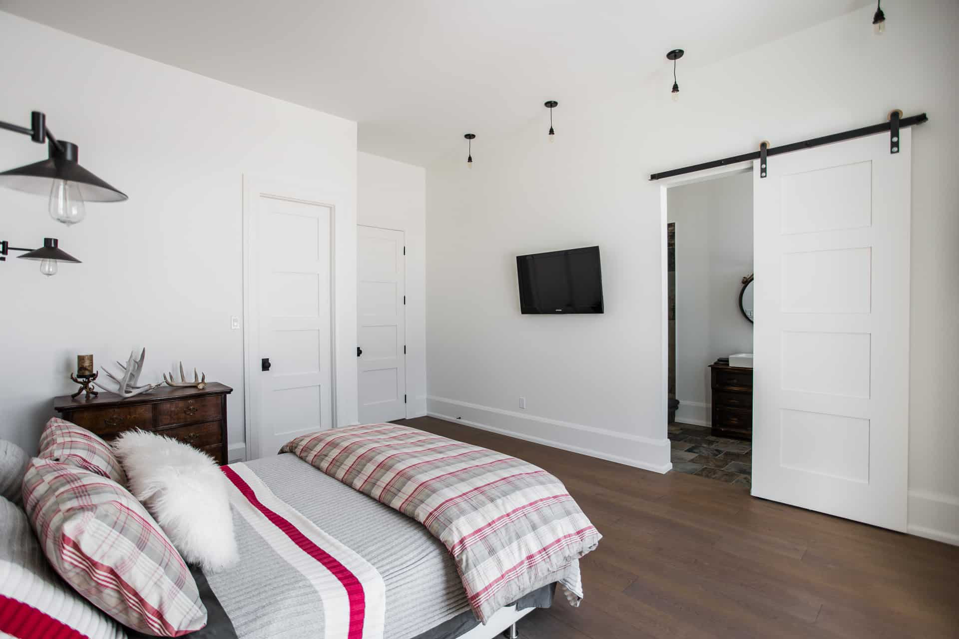 A classic wooden barn door sliding smoothly on a black track, offering privacy and style to a home office setup.