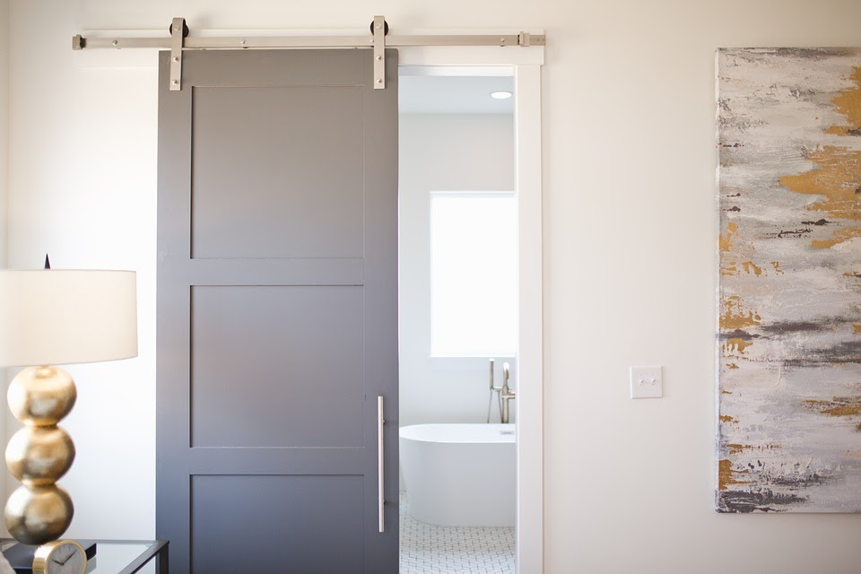 Sliding bathroom door with a modern track system in a spacious bathroom.
