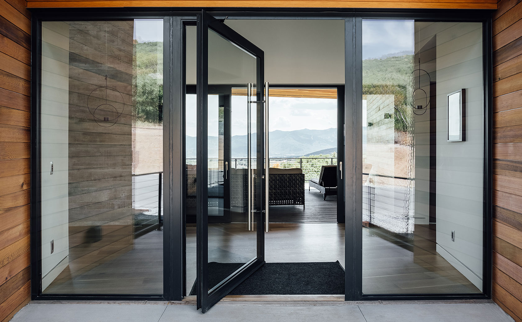 Custom wooden pivot door with a unique vertical grain design, seamlessly blending with contemporary interiors.
