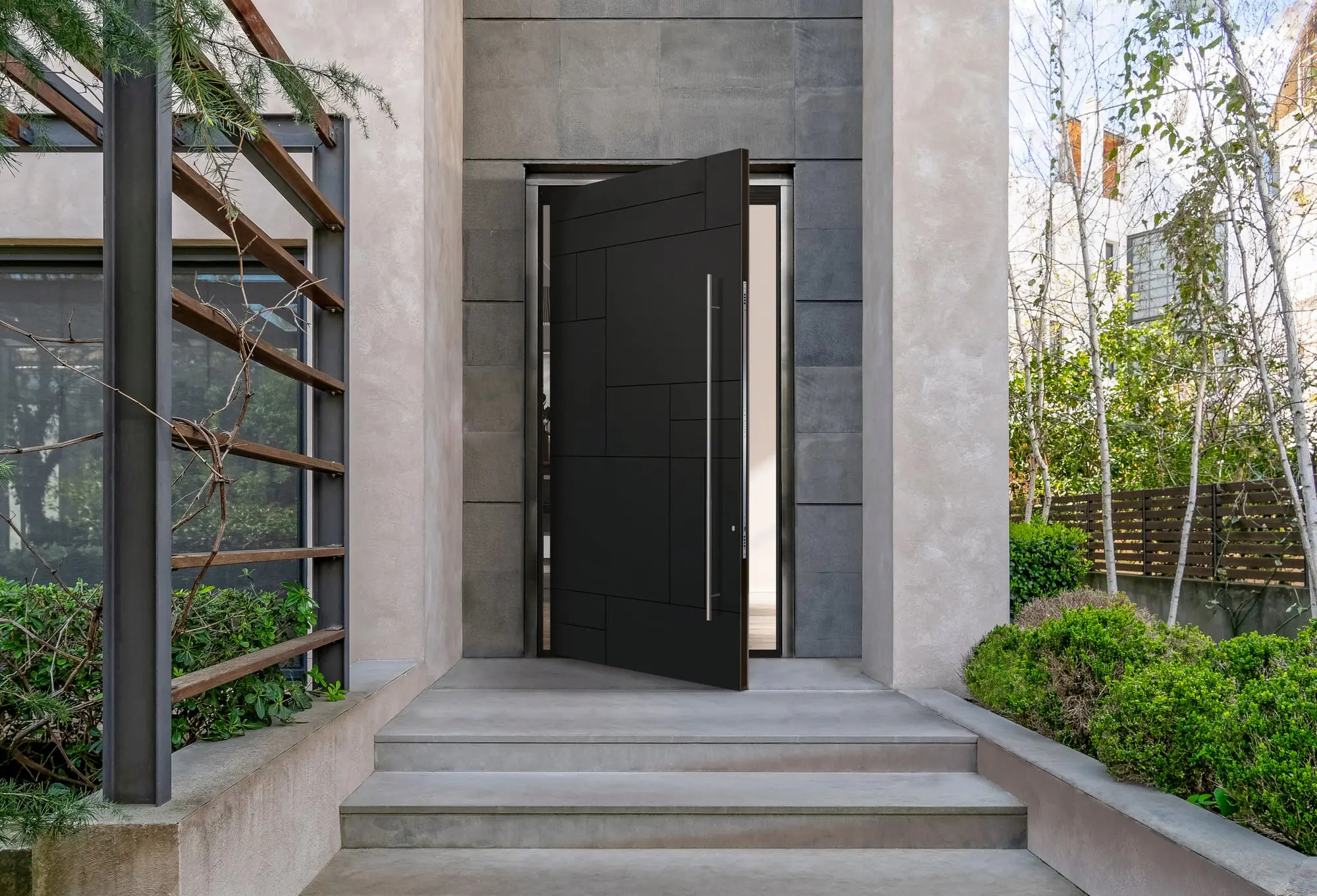Large pivot door with intricate carvings, combining traditional craftsmanship with modern architecture.